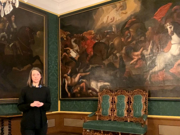 Wissenschaftliche Volontärin Stella Gilfert vor dem historischen Gemälde.