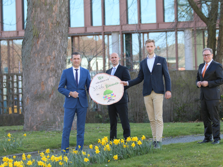 Patrick Pietschmann (links), Vorstandsmitglied der Volksbank BraWo, übergibt symbolisch 3.026 Bäume an Janis Meyerhof von den Niedersächsischen Landesforsten (3. von links) im Beisein von André Bonitzke, Leiter Privatkunden von der Volksbank BraWo, und Thomas Fast, Botschafter von United Kids Foundations.
