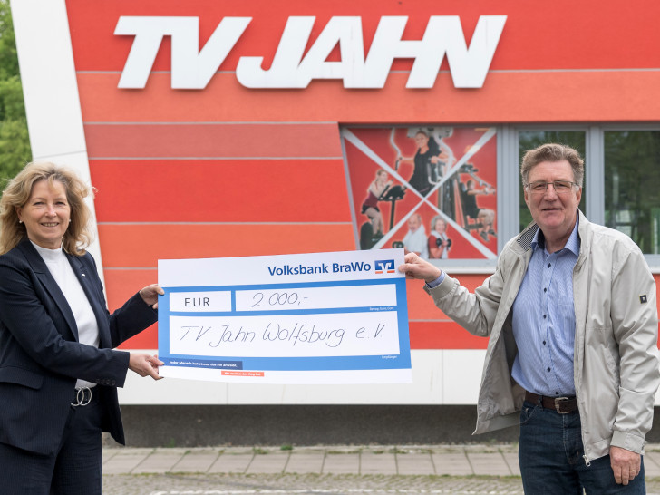 Claudia Kayser, Leiterin der Direktion Wolfsburg der Volksbank BraWo, übergibt die Spende symbolisch an Dirk Räke-Maresté, Geschäftsführer des TV Jahn Wolfsburg.