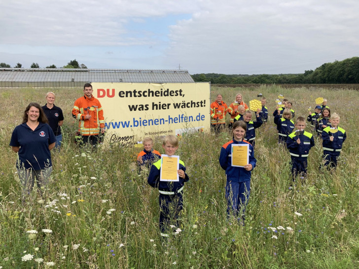die Kinder- und Jugendfeuerwehr Melverode mit den Urkunden zur Patenschaft auf ihrer Blumenwiese: Corina Gerlach (Kinderfeuerwehrwartin), Jennifer Ulbrich (stellvertretende Kinderfeuerwehrwartin), Simon Jakobi (Jugendfeuerwehrwart) und Nathalie Lemke (Betreuerin) mit  Rebecka Bruns (Brandschutzerzieherin)