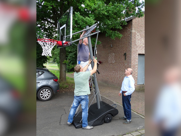 Aufbau der neuen Basketballkörbe. Auf der Leiter stehend der 2. Bürgermeister Helmut Scheffler, davor stehend der MTV-Vorsitzende Carsten Voigt und rechts stehend der Bürgermeister Bruno Polzin.