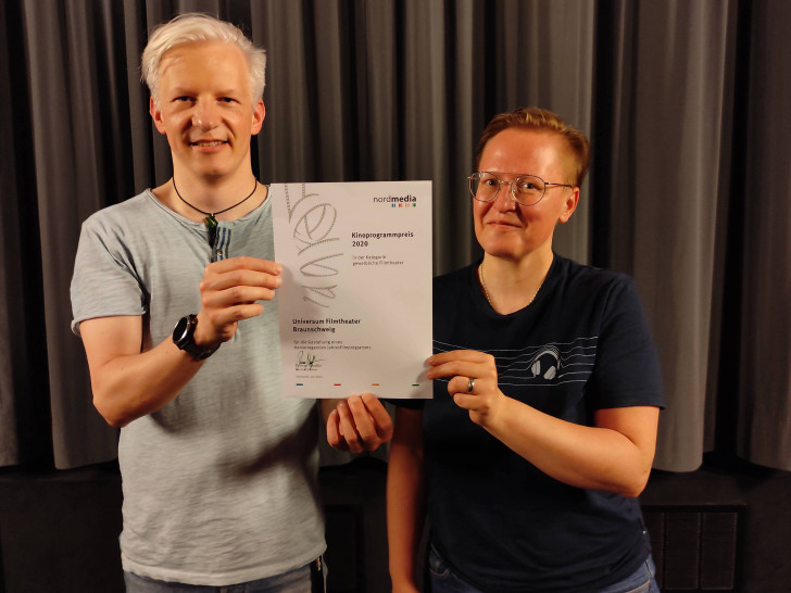 Stabübergabe im Universum Filmtheater Braunschweig: Tobias Jung und Anke Hagenbüchner freuen sich über die jüngste Auszeichnung des Programmkinos durch die Nordmedia, Juli 2021.
