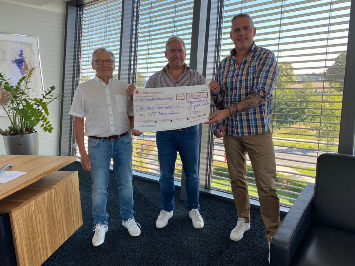 Vorschlag für die BU: Maik Tauchert, Gründer und Geschäftsführer der MT Massivhaus Gruppe (Mitte) überreicht den symbolischen Spendenscheck in Höhe von 100.000 Euro an Manfred Reinecke (links) und Joachim Franz (rechts) vom Vorstand des BE YOUR OWN HERO e.V.. Der Betrag wurde zur Renovierung der Reichenau Mission Primary School in Underberg/Südafrika eingesetzt.