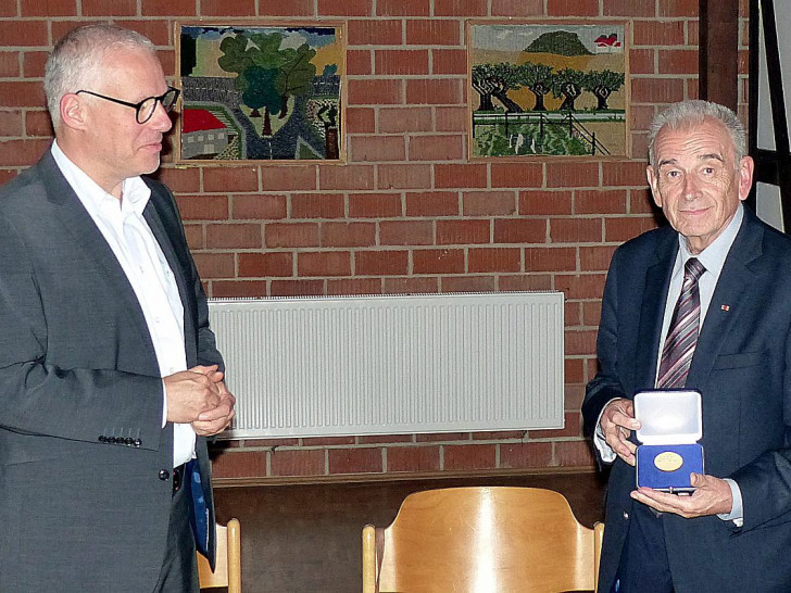Marco Trips (links) überreicht Herrn Klaus-Dieter Arndt die Ehrenmedaille des NSGB für 50 Jahre Ratstätigkeit.