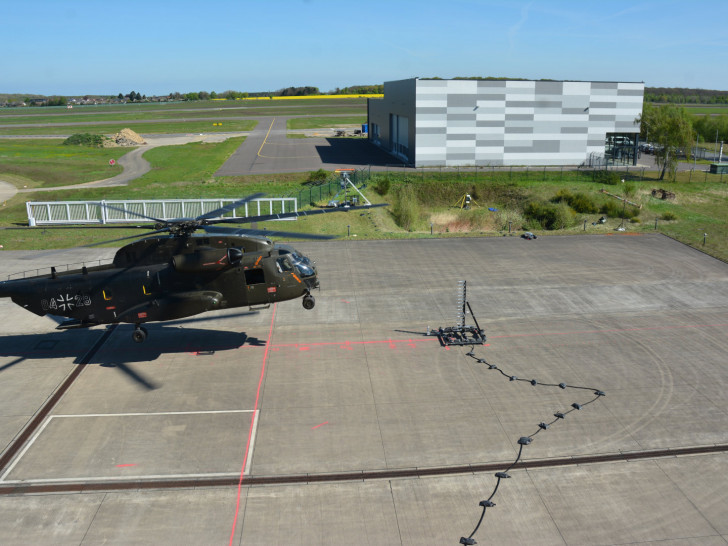 Der He­li­ko­pter CH-53 der Bun­des­wehr flog bei den Ver­su­chen in 2 bis 12 Me­tern Hö­he über dem Roll­feld. Fünf Ka­me­ras nah­men ihn und die Luft­wir­bel an den Ro­to­ren da­bei in den Blick.