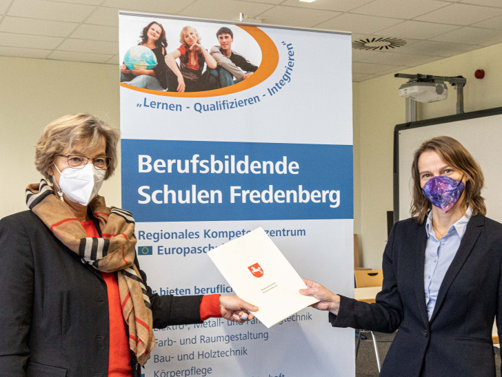 Schuldezernentin Andrea Hartmann (re.) übergibt Anja Wolfgram-Funke die Urkunde.