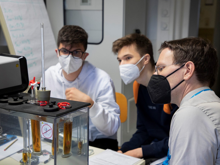 Prof. Dr. Henning Zindler (rechts) und zwei Schüler beim Versuch am Kapillarviskosimeter.