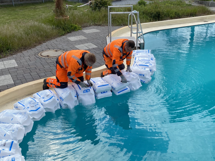 Mitarbeiter des Betriebshofes beim Einfüllen des für Grasleben charakteristischen Salzes in das Becken des Freizeitbades. 