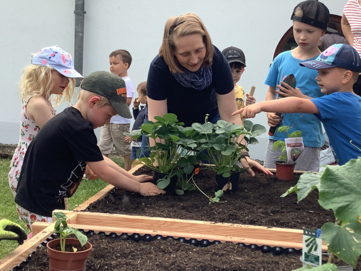 Projektleiterin Mireille Müller mit den Kids der Kita bei der Hochbeetbepflanzung. Auch Eltern halfen tatkräftig mit.