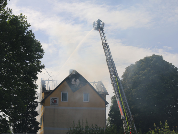 Von der Drehleiter aus bekämpft die Feuerwehr den Dachstuhlbrand in der Töpferstraße. Es ist innerhalb von vier Wochen der fünfte Brand dieser Art.