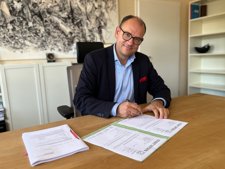 Bürgermeister Erik Homann unterzeichnet den Förderantrag.