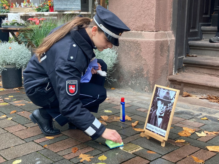 Eine Polizistin pflegt einen der Stolpersteine in de Goslarer Altstadt.
