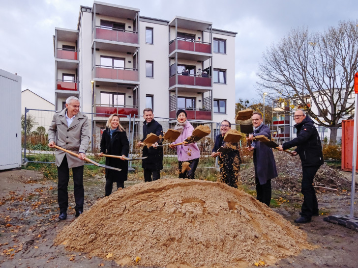 Gute Laune aller Beteiligten beim Spatenstich der Neuland im Schlesierweg in Wolfsburg für das nächste „Wohnen für Alle“-Projekt. Im Hintergrund sind die bereits voll vermieteten Gebäude aus den ersten beiden Bauabschnitten zu sehen.