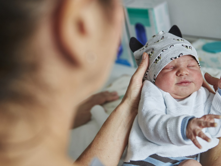 Eine Hebamme der Asklepios Harzkliniken mit einem Baby.
