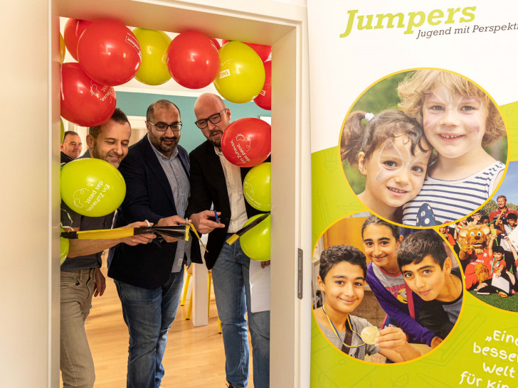 Die neuen Lernräume sind eröffnet: Markus Gruner von Jumpers_Samir Roshandel von Bildungshelden und Henrik Kreime von der TAG Wohnen durchschneiden das Absperrband.