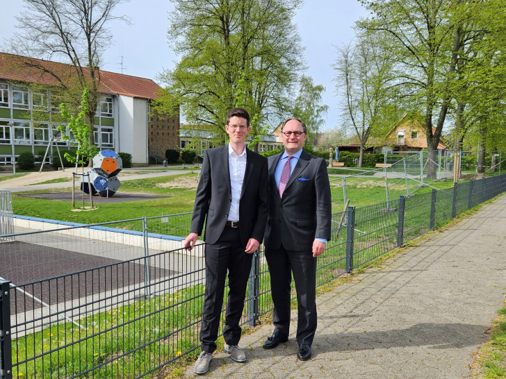 Bürgermeister Tobias Grünert (li.) und Ortsbürgermeister Olaf Marotz begutachten den neuen Zaun am Jugendplatz an der Hildesheimer Straße.