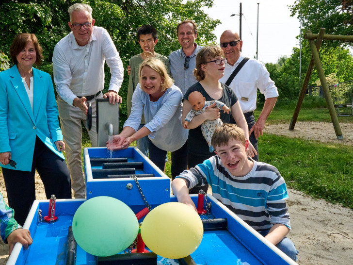 Sie freuen sich mit den Kindern und Mitarbeitenden im Landhaus Querum über die fertiggestellte Wasserspielanlage: Angelika Rimatzki - Stiftungsvorständin der Stiftung ‐ Unsere Kinder in Braunschweig (links im Bild), Marcus Eckhoff - Geschäftsführer Neuerkeröder Wohnen und Betreuen GmbH (Zweiter von links) und Dr. Joachim Gulich von der Stiftung Braunschweiger Land (Zweiter von rechts). 