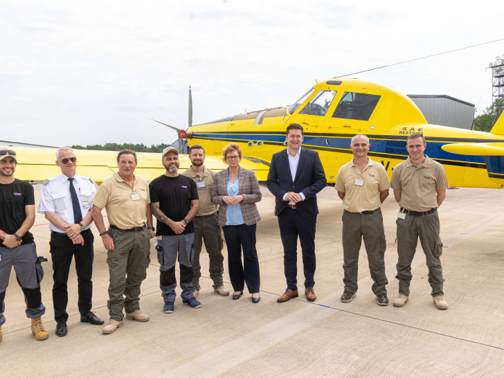 Ministerin Daniela Behrens zusammen mit Oberbürgermeister Dr. Thorsten Kornblum und der Crew vor dem neuen Löschflugzeug.