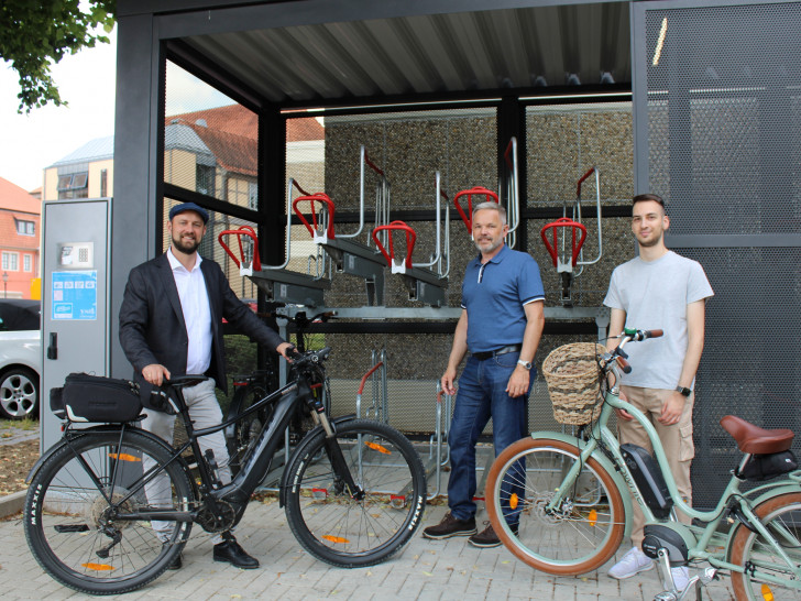 v.li.: Bürgermeister Malte Schneider, Thomas Hoffmann (Fachbereichsleiter Bauen und Umwelt) und Mitarbeiter Ferhat Kara freuen sich, dass die beiden Fahrradabstellboxen nun in Betrieb genommen werden konnten.