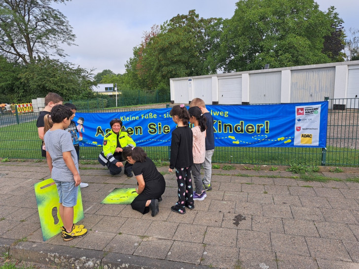 Die  Verkehrssicherheitsberaterin sprüht im Umkreis verschiedener Grundschulen in Salzgitter gelbe Fußabdrücke auf den Gehweg. Dabei hatte sie auch Hilfe von Kindern.. 