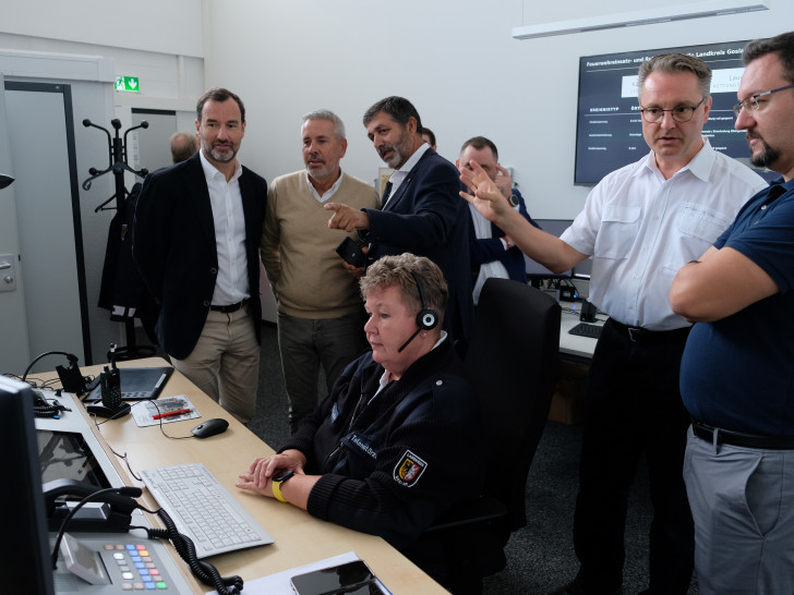 Dr. Tobias Steffen (Zweiter von rechts) erläutert den telenotfallmedizinischen Arbeitsplatz in der Rettungsleitstelle.