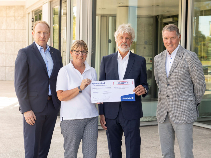 Marc Knackstedt, Vorsitzender des Vorstandes der Öffentlichen (links), und sein Vorgänger Knud Maywald (rechts) übergeben die Spenden an Dr. Thomas Lampe, 1. Vorsitzender des Vereins WegGefährten, und Petra Gottsand, Geschäftsführerin des Hospizes am Hohen Tore.