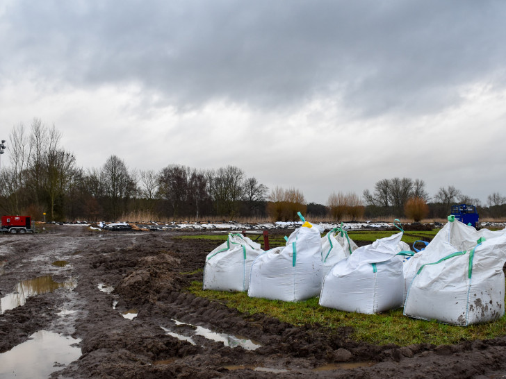 Hochwasser-Einsatzstelle in der Samtgemeinde Flotwedel. Im Vordergrund stehen so genannte "Big Packs" mit Sand bereit. Im Hintergrund ist ein mit Sandsäcken verstärkter Deich zu sehen.