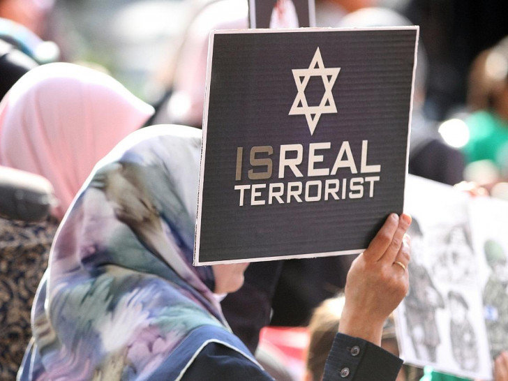 Demonstrantin mit "Isreal Terrorist"-Plakat (Archiv)