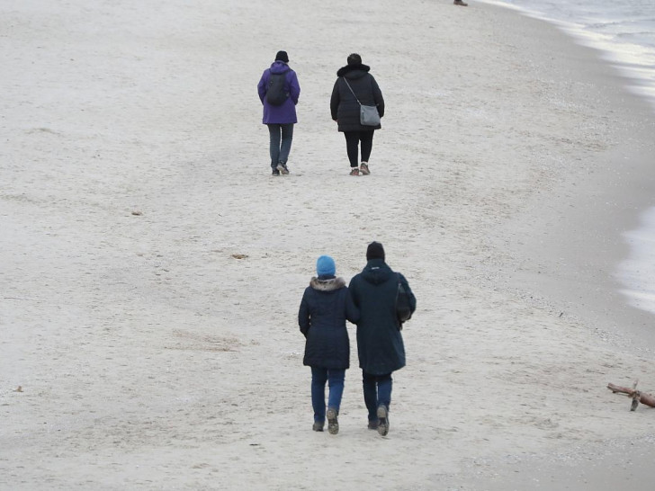 Paare gehen am Strand spazieren