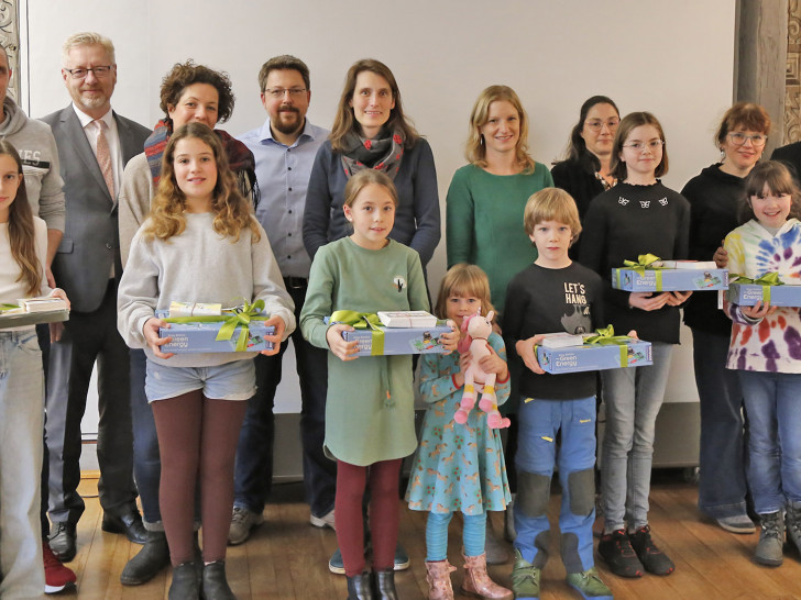 Die Gewinnerin des Wettbewerbs, Hetty Volze (vordere Reihe, links) und die Zweitplatzierten Carla Loch, Sophie Michaelis, Vinzenz Käbitz, Merle Hauswirth und Juliana Stephan mit den stolzen Eltern im Hintergrund sowie KVG-Geschäftsführer Axel Gierga (3. v. l.) und Bürgermeister Ivica Lukanic (r.).