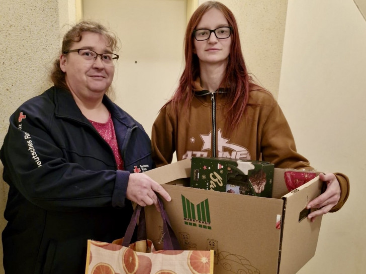 Yvonne Pischke (links) übergibt abgegebene Spenden an die Mutter der Familie, Hanna Popovic.