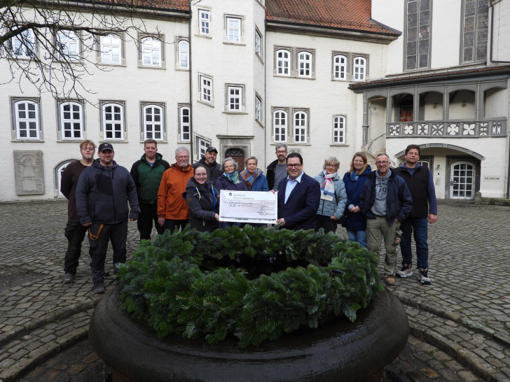 Tobias Heilmann, Landrat des Landkreises Gifhorn, überreichte den Spendenscheck im Beisein etlicher Helfer des „Schlossmarkts zum Advent“ an Nina Siebert, Vorsitzende des Vereins Helfen vor Ort.