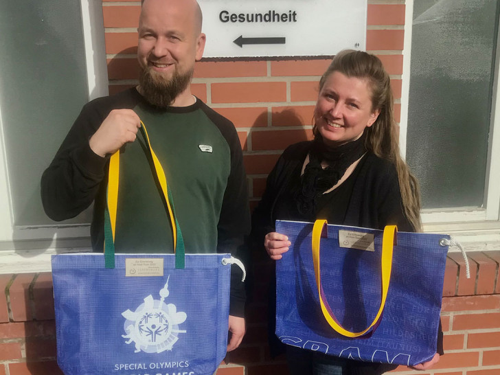 Die Upcycling-Taschen als besondere Erinnerung. Stefan Mandel (Lebenshilfe, links) überreicht zwei Taschen an Christina Trittel, Inklusionsbeauftragte des Landkreises.