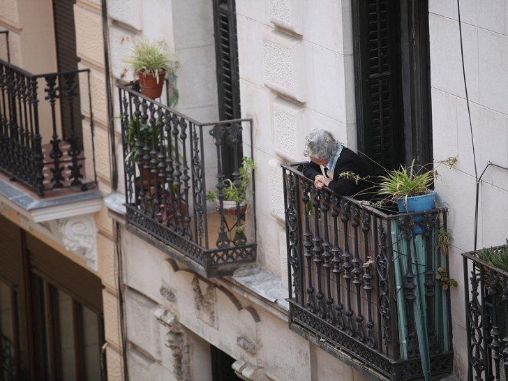 Seniorin schaut von einem Balkon (Archiv)
