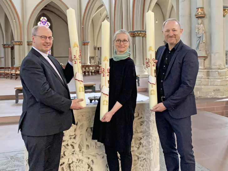 Propst Martin Tenge (links) hat die Osterkerzen am heutigen Gründonnerstag an Dompredigerin Cornelia Götz und Propst Lars Dedekind vor dem Altar in St. Aegidien übergeben. 