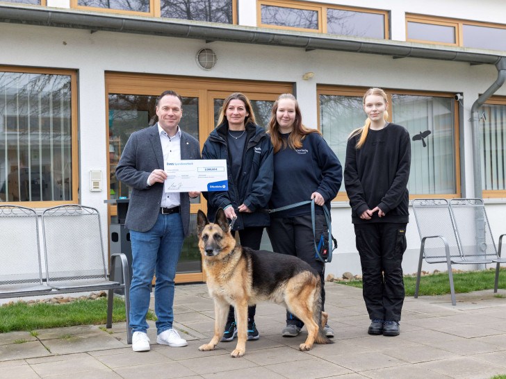 Gordon Grund, Partner der Öffentlichen in Helmstedt, übergibt die Spende an Katharina Roye, Anna Reichert und Merle Laas vom Team des Tierheims (von links nach rechts) – auch Schäferhund Sputnik freut sich über den unverhofften Gewinn.
