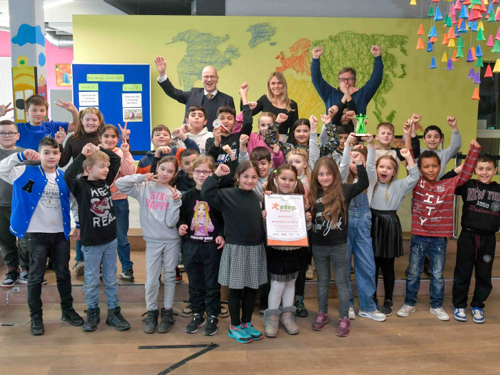 Die Kinder freuen sich über ihre Siegerurkunden, 250 Euro Preisgeld für die Klassenkasse und den Pokal, was ihnen Stefan Honrath (oben links), Botschafter von United Kids Foundations und Leiter der Direktion Peine der Volksbank BRAWO, überreichte.