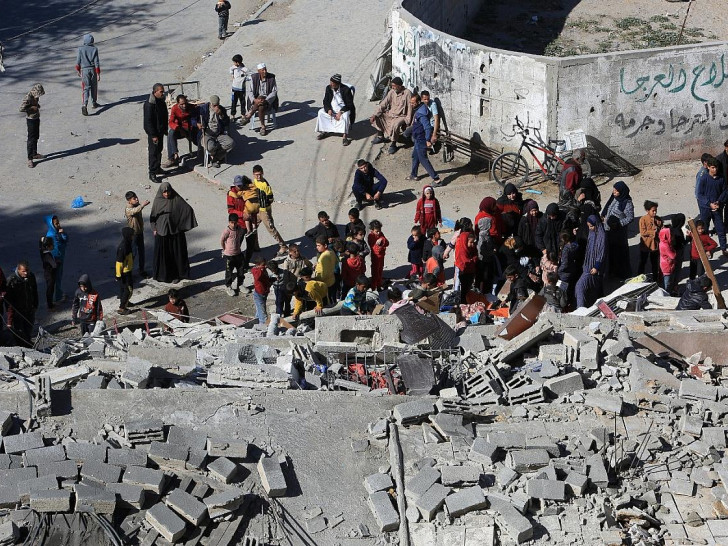 Menschen versammeln sich an einem zerstörten Haus in Rafah am 12.03.2024