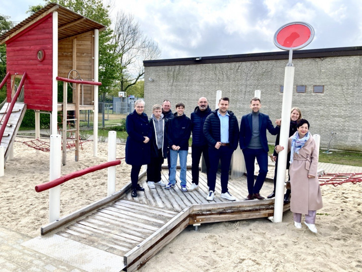 Oberbürgermeister Dennis Weilmann und weitere Vertreter aus der Politik freuen sich über die neuen Außenanlagen der Peter-Pan-Schule.