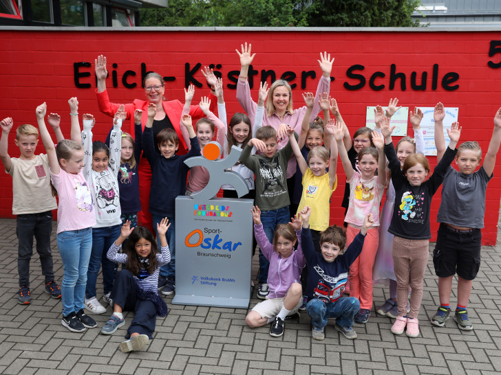 Schüler der Erich-Kästner-Schule in Weddel freuen sich über die Sport-Oskar Trophäe, die ihnen von Nicole Mölling, Botschafterin von United Kids Foundations, übergeben wurde.