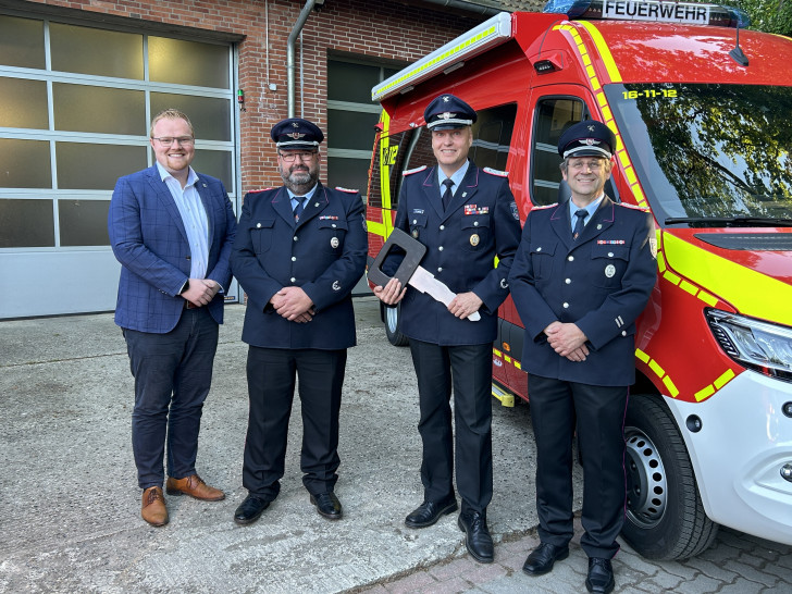 Vor dem neuen Einsatzfahrzeug: Samtgemeindebürgermeister Henning Evers (links) zusammen mit der Feuerwehr.