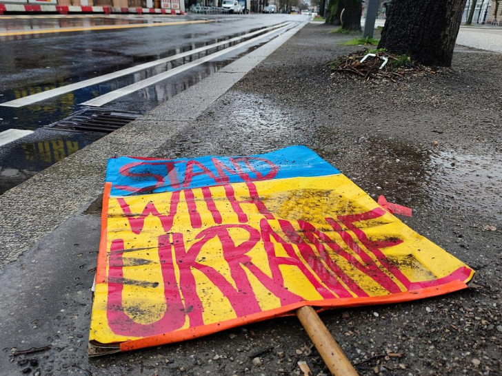 Schild "Stand with Ukraine" liegt auf dem Boden (Archiv)
