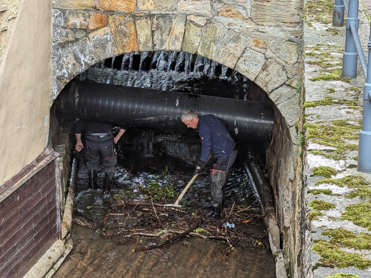 Das freiliegende Abwasserrohr unterhalb der Königsbrücke stellt eine zusätzliche Herausforderung dar: Hier können sich Treibgut und Totholz leicht verkeilen. Die Entfernung der Anschwemmungen kann aber nur per Hand und Schaufel erfolgen.