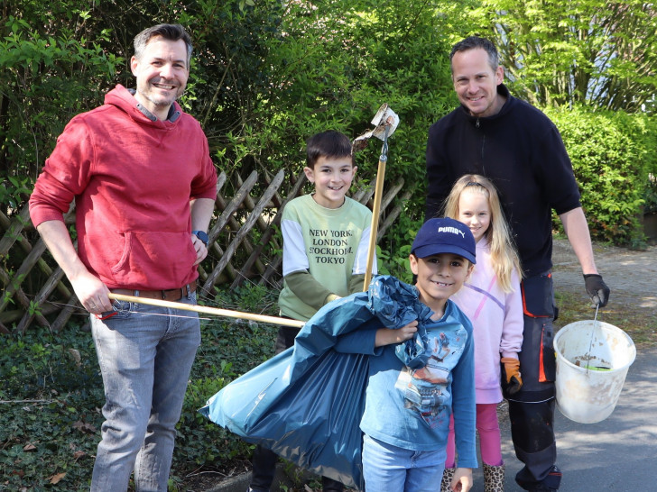 Väter sammelten mit ihren Kindern Müll im Dorf ein. 