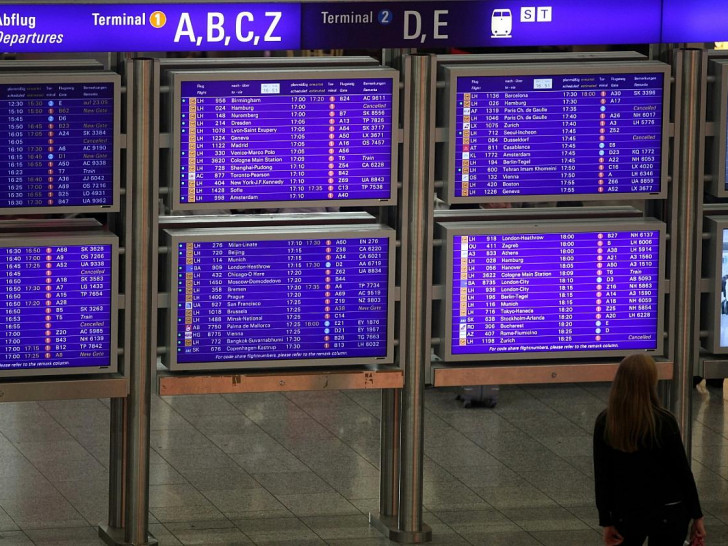 Frau vor Informationstafel am Frankfurter Flughafen