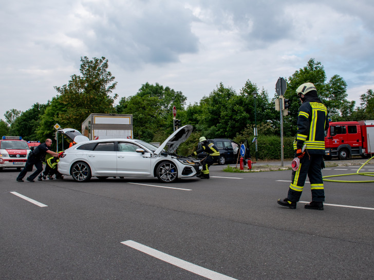 Mit vereinten Kräften wird eins der Unfallfahrzeuge von der Bundesstraße geschoben.