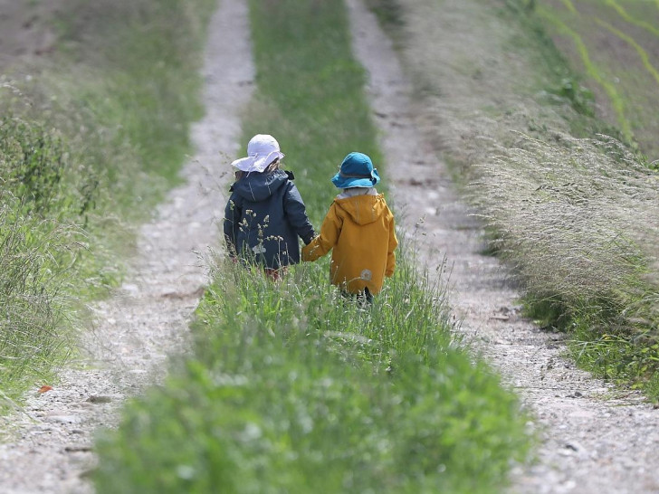 Zwei kleine Kinder laufen auf einem Feldweg (Archiv)