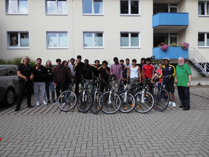 Gruppenfoto mit den Jugendlichen nach dem Fahrradparcours und am Reaktionstest-Fahrsimulator.