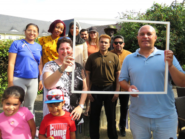 Zusammen und gemeinsam: Geflüchtete, die eine neue Heimat im Landkreis gefunden haben, treffen sich zum interkulturellen Picknick. Links am Bilderrahmen Christel Seigneur.