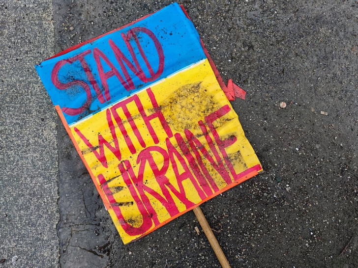 Schild "Stand with Ukraine" liegt auf dem Boden (Archiv)